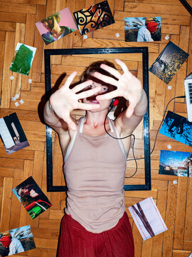 Portrait of a beautiful girl on the floor with photos around her