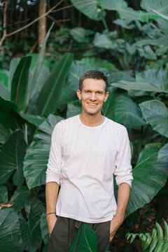 Smiling adult man in lush vegetation