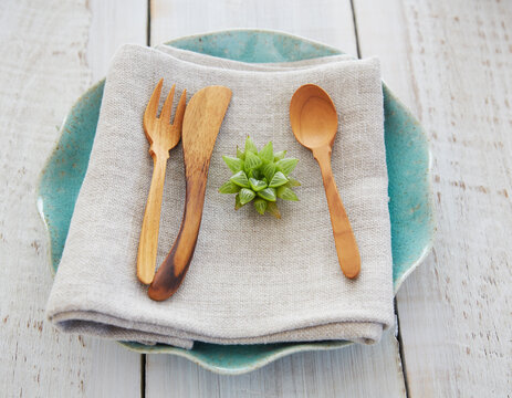 Dinner plate with linen napkin and wood utensils