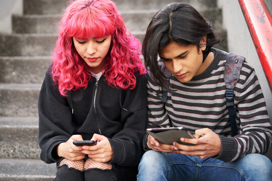 Young hip couple using cell phones