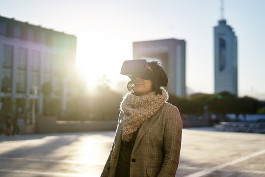 Young woman using a VR headset outdoors