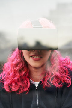Double exposure of pink hair woman using virtual reality headset