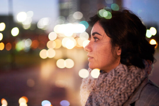 Young woman at busy intersection at night