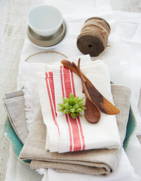 Stack of linens with wood utensils