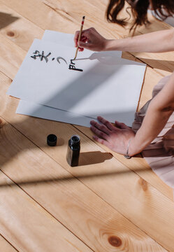 Unrecognizable female creating calligraphy
