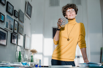 Woman with curly brown hair working in a studio office