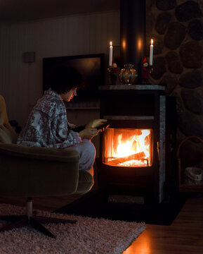 Girl with smartphone near the fireplace