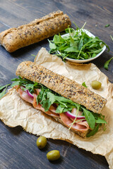 Sandwich with Italian mortadella, arugula and multi-grain baguette. take away food. junk food