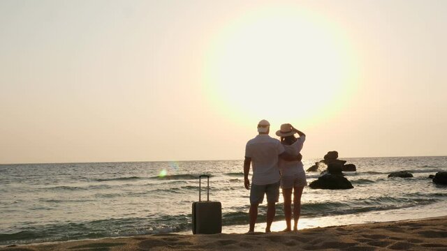Romantic couple of lovers, silhouettes. travelers hug and enjoy sea view, sunrise or sunset, on the beach. travel concept. Honeymoon. seaside vacation