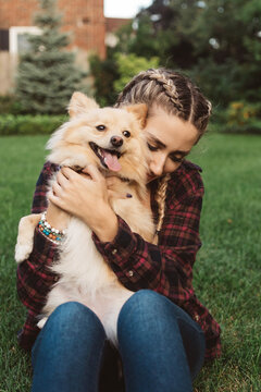 Two female friends in their twenties playing with their dogs outside in autumn