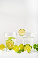 Drink glasses with water ,lime,mint and ice on white background