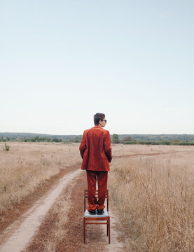 Anonymous woman in suit on chair in nature