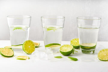 Fototapeta premium Drink glasses with water ,lime,mint and ice on white background
