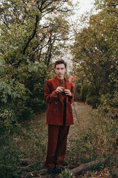 Woman in vintage suit standing in autumn woods