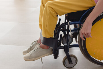 Obraz premium Close up photo of disable child sitting on the wheelchair in hospital walk way, His hand controlling the wheel, Life in the education age of children, Happy cerebral palsy kid concept.