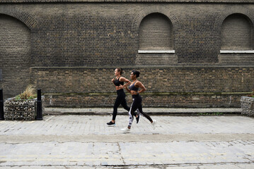 Sportswomen running together outdoors.