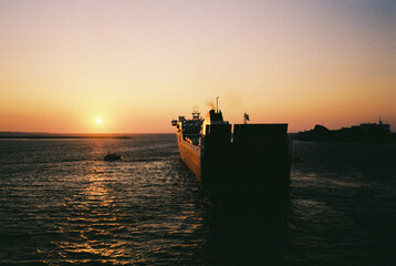 A ferry leaving the port in the sunset.