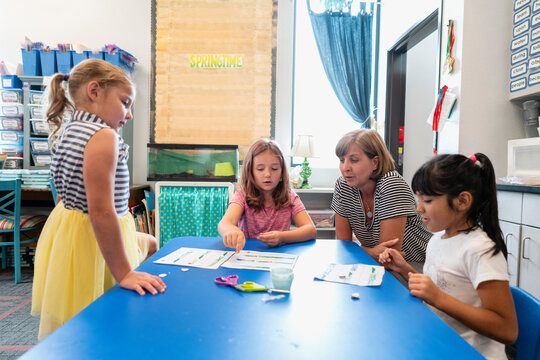Students in classroom playing a game with teacher watching