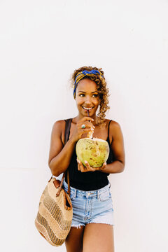Portrait of happy mixed race woman with fresh coconut