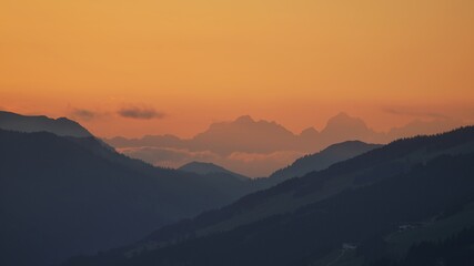 beautiful sunset on the mountains with orange sky and view to the alps