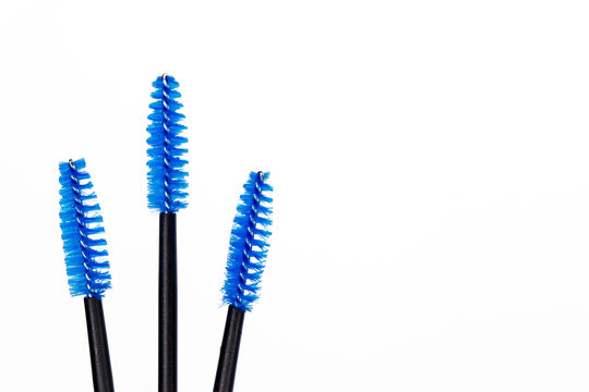 Few color eyelash brush on white background. Blue, black and soft pink eyelash brush for girl master eyelash extension. Professional makeup tools for eyelashes and eyebrows. Beauty concept for salon