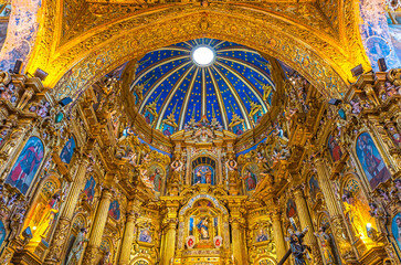 Fototapeta na wymiar Baroque interior of the San Francisco church with gold leaf decorations and blue dome, Quito, Ecuador.
