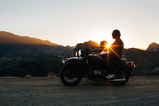 Young Anonymous Couple Watching California Sunset on Vintage Mot