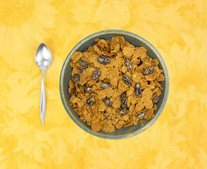 Bran flake cereal with raisins in a stoneware bowl