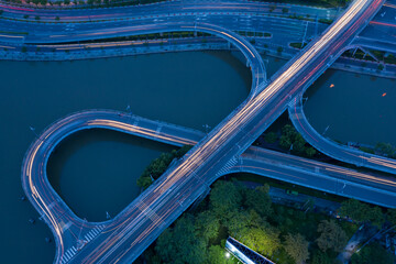 top down drone shot of Nguyen Van Cu bridge, motorway and interchange above the canal with curves...