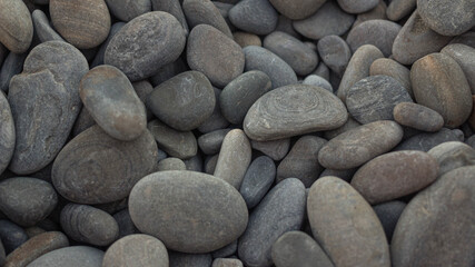 Fototapeta na wymiar Many smooth sea stones on the beach