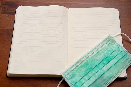 healthcare_hygienic mask_notebook_wooden background