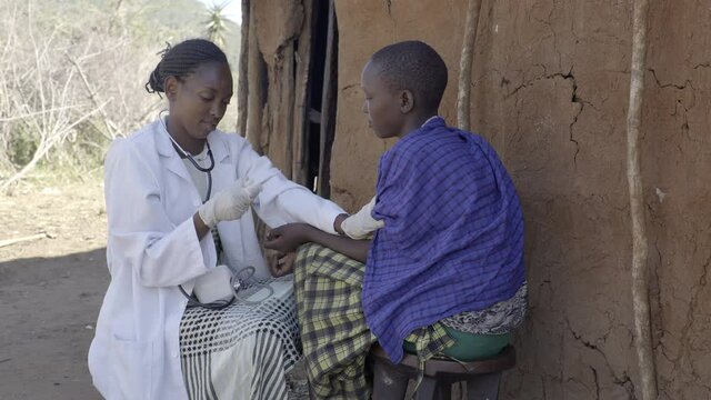 Female doctor examining patient in rural community,  Kenya, Africa