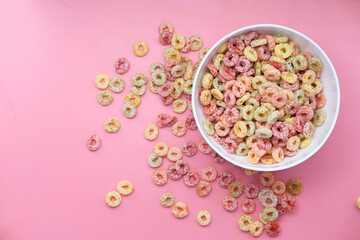 colorful ring corn flakes in a bowl on pink background 