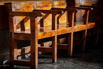 Late afternoon sun shines on a 16th century wooden bench in the convent of Santo Domingo in Cusco, Peru.