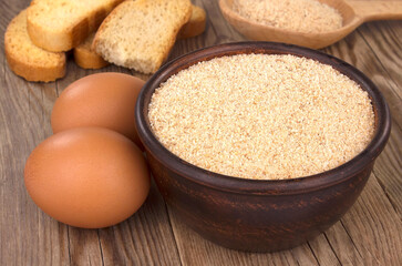 Bowl with breadcrumbs on wooden table