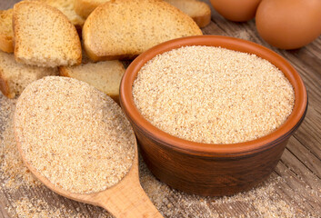Bowl with breadcrumbs on wooden table