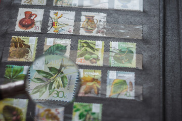 Still life with stamps in an album and magnifying glass. Ukrainian stamps
