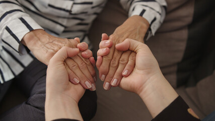 Close up mature elderly woman holding hands of grown up daughter, showing love and care. High...