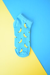Blue fashionable socks with banana pattern print on blue and yellow background