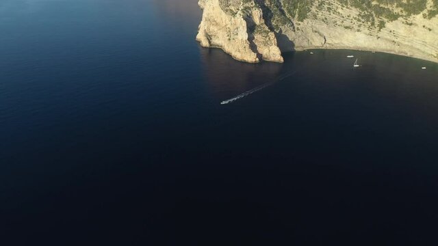 Boat speeding away from the offshore coast, off the coast of Ibiza.