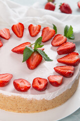 Sweet breakfast, delicious cheesecake with fresh strawberries and mint, homemade recipe without baking, on a blue stone table. Copy space.
