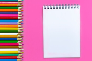School colorful multicolor pencils and paper note on pink, flat lay, top view, back to school, copy space, mockup