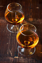 Two glasses of brandy or cognac on  dark table