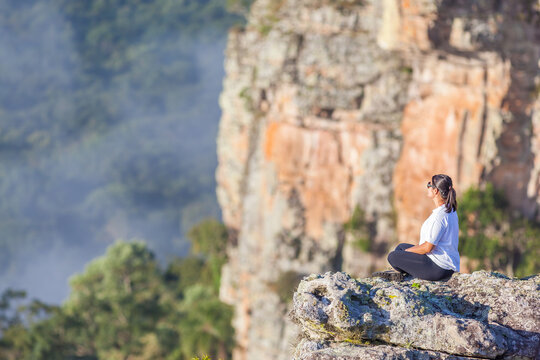 Girl resting on the top of cliffs at Guartela Canyon, sixth largest canyon in the world in length - Tibagi/ Parana - Brazil