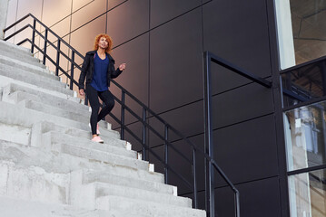 Young european redhead woman have walk on the stairs outdoors