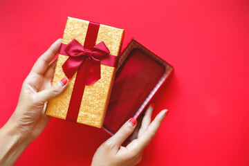 female hands with beautiful manicure open a gift box