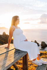 Portrait of a pregnant woman against an oceanic landscape