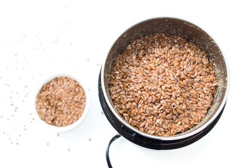 Flax seeds in a coffee grinder on a white background. Natural omega replacement