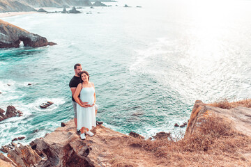 Pregnant couple on the edge of a cliff