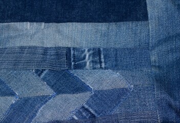 Blue denim jeans patchwork pattern. Concept of old jeans reuse and natural resources preserving. 